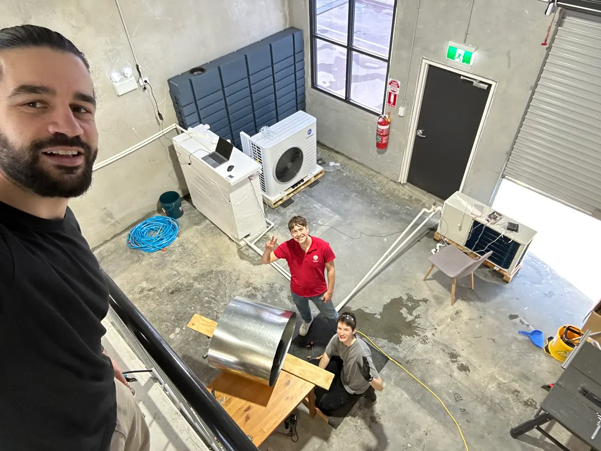 The Thermal Dawn team in the Hornsby workshop, with heat pumps and a thermal store on the bench